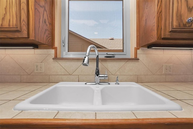 3217 Quail Cir, Altus, OK 73521 - detailed view of tile counters, brown cabinetry, and tasteful backsplash