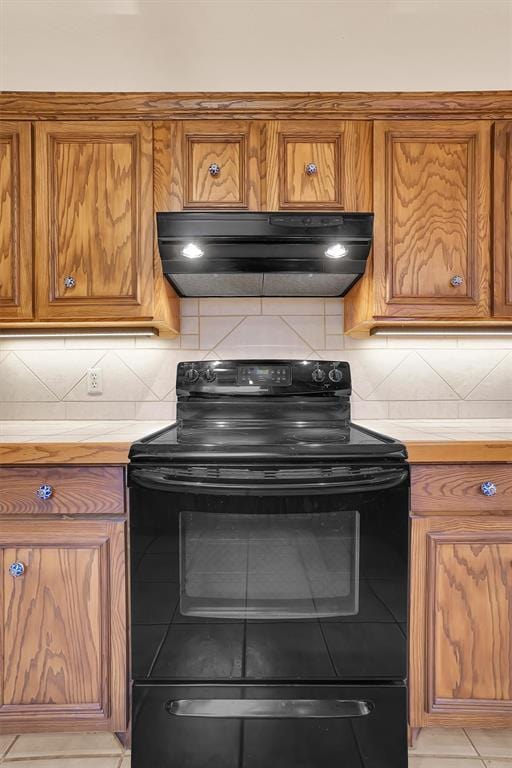 3217 Quail Cir, Altus, OK 73521 - kitchen featuring black electric range, exhaust hood, brown cabinets, and light countertops
