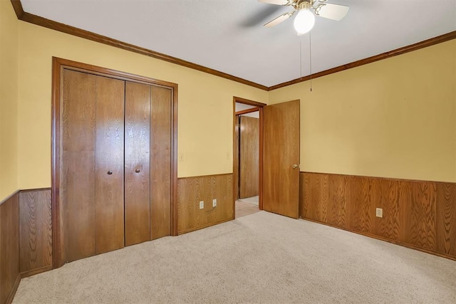 3217 Quail Cir, Altus, OK 73521 - unfurnished bedroom with wainscoting, carpet floors, wood walls, a closet, and crown molding