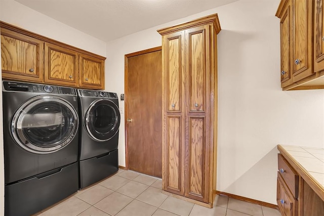 3217 Quail Cir, Altus, OK 73521 - washroom featuring separate washer and dryer, cabinet space, and light tile patterned floors