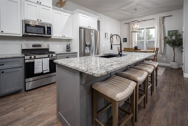 1540 17th Pl, Newcastle, OK 73065 - kitchen featuring stainless steel appliances, gray cabinets, dark wood-type flooring, decorative backsplash, and light stone counters
