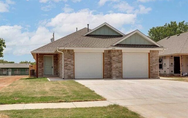 1426 SW Oklahoma Ave, Lawton, OK 73501 - view of front facade featuring an attached garage, concrete driveway, board and batten siding, a front lawn, and brick siding