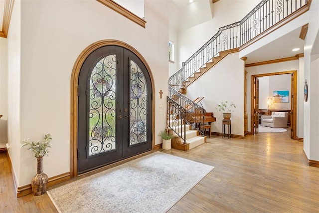 1605 Hidden Lake Dr, Edmond, OK 73034 - entryway featuring arched walkways, french doors, wood finished floors, a towering ceiling, and stairs