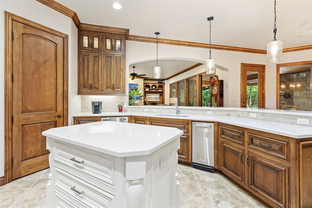 1605 Hidden Lake Dr, Edmond, OK 73034 - kitchen featuring ornamental molding, a center island, backsplash, brown cabinetry, and decorative light fixtures