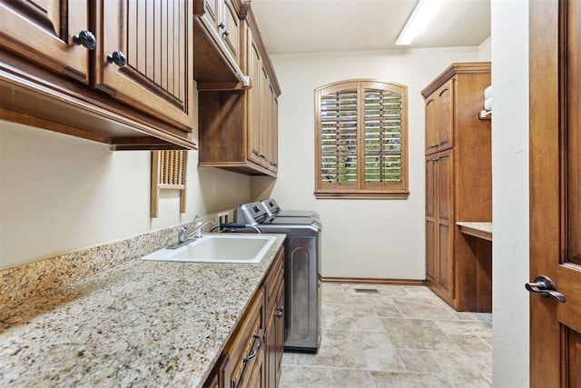 1605 Hidden Lake Dr, Edmond, OK 73034 - washroom featuring cabinet space, washer and clothes dryer, and stone finish flooring
