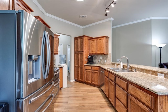 1604 Central Pkwy, Norman, OK 73071 - kitchen featuring stainless steel appliances, light wood finished floors, brown cabinets, backsplash, and crown molding