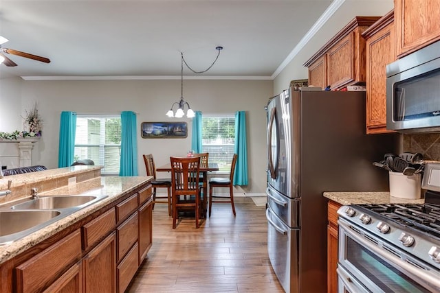1604 Central Pkwy, Norman, OK 73071 - kitchen featuring appliances with stainless steel finishes, brown cabinets, plenty of natural light, ceiling fan, and ornamental molding