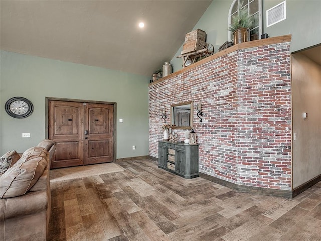 4920 W Forrest Hills Rd, Guthrie, OK 73044 - living room with wood finished floors, high vaulted ceiling, and brick wall