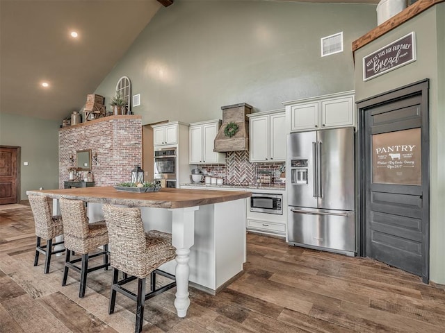 4920 W Forrest Hills Rd, Guthrie, OK 73044 - kitchen featuring stainless steel appliances, butcher block countertops, high vaulted ceiling, a kitchen island, and backsplash