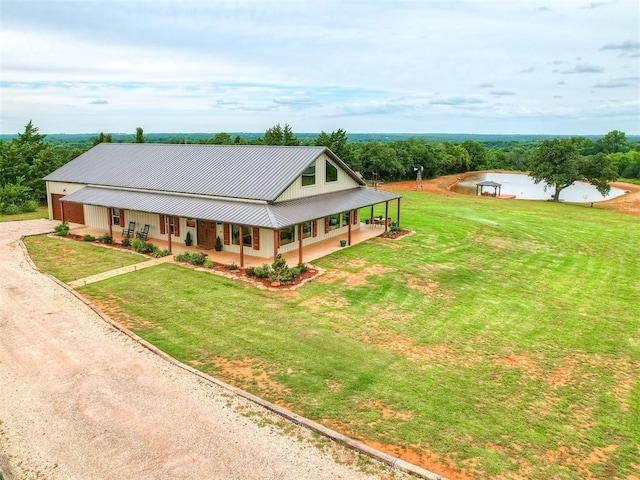 4920 W Forrest Hills Rd, Guthrie, OK 73044 - view of front of house featuring covered porch, dirt driveway, a front lawn, a metal roof, and a standing seam roof