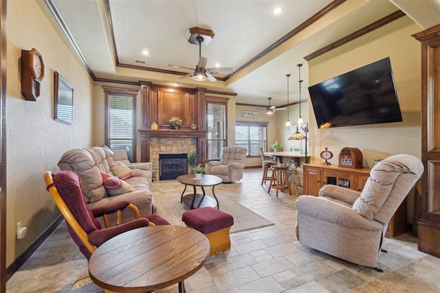 12816 NW 6th St, Yukon, OK 73099 - living area with a ceiling fan, a fireplace, a raised ceiling, stone tile floors, and ornamental molding
