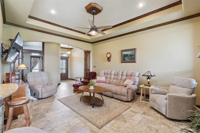 12816 NW 6th St, Yukon, OK 73099 - living room featuring ornate columns, a tray ceiling, arched walkways, stone tile floors, and ornamental molding