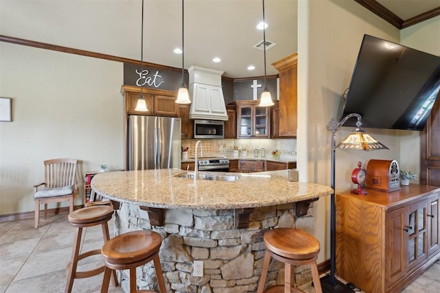 12816 NW 6th St, Yukon, OK 73099 - kitchen featuring appliances with stainless steel finishes, ornamental molding, a kitchen breakfast bar, decorative backsplash, and light stone counters
