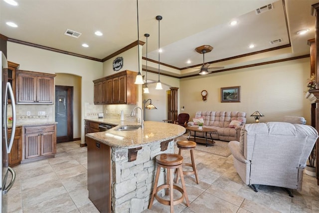 12816 NW 6th St, Yukon, OK 73099 - kitchen with ornamental molding, a ceiling fan, decorative backsplash, a peninsula, and a breakfast bar area