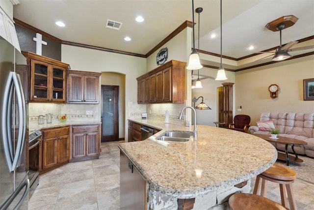 12816 NW 6th St, Yukon, OK 73099 - kitchen with crown molding, appliances with stainless steel finishes, a peninsula, a kitchen breakfast bar, and tasteful backsplash