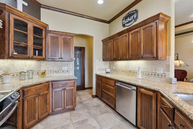 12816 NW 6th St, Yukon, OK 73099 - kitchen with appliances with stainless steel finishes, crown molding, decorative backsplash, glass insert cabinets, and light stone counters