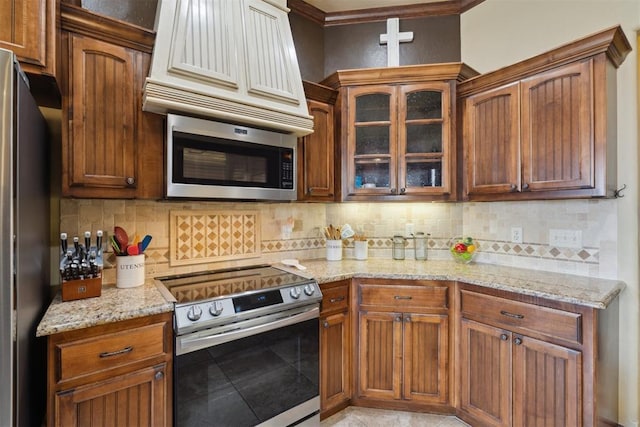12816 NW 6th St, Yukon, OK 73099 - kitchen with appliances with stainless steel finishes, glass insert cabinets, light stone counters, and tasteful backsplash