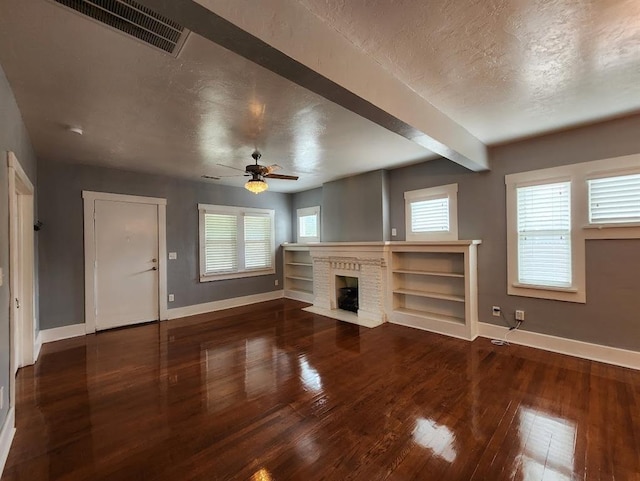 2719 NW 14th St, Oklahoma City, OK 73107 - unfurnished living room with a textured ceiling, wood-type flooring, a brick fireplace, and ceiling fan