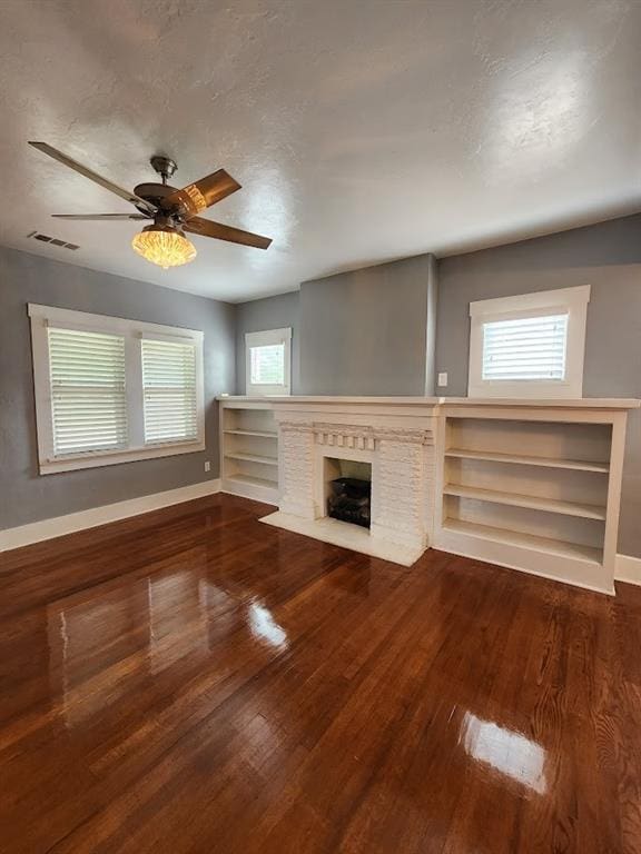 2719 NW 14th St, Oklahoma City, OK 73107 - unfurnished living room with healthy amount of natural light, wood finished floors, a fireplace, and ceiling fan