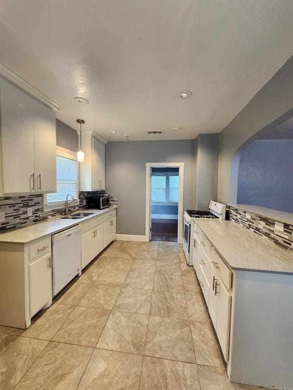 2719 NW 14th St, Oklahoma City, OK 73107 - kitchen featuring white appliances, decorative backsplash, light countertops, white cabinets, and recessed lighting