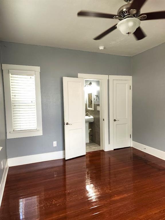 2719 NW 14th St, Oklahoma City, OK 73107 - unfurnished bedroom with wood finished floors, connected bathroom, and a ceiling fan