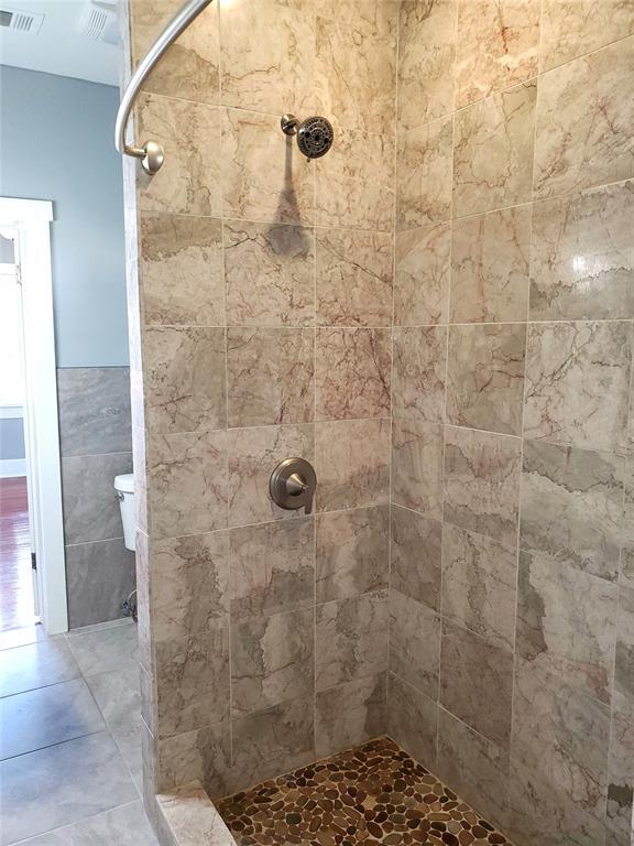 2719 NW 14th St, Oklahoma City, OK 73107 - full bathroom featuring tiled shower and tile walls