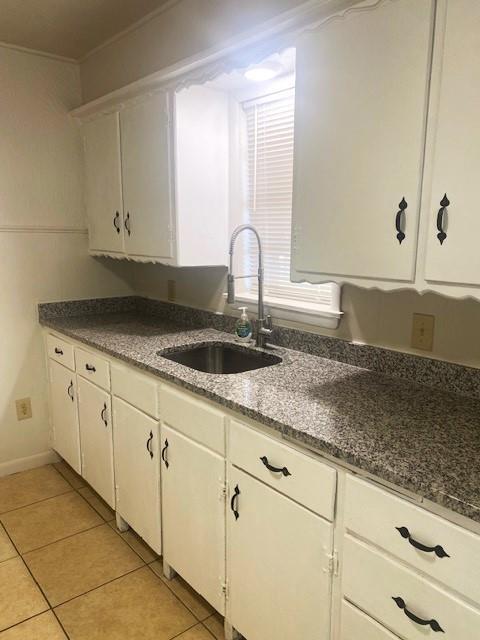 6101 S Douglas Ave, Oklahoma City, OK 73139 - kitchen featuring white cabinets, light tile patterned flooring, and dark stone counters