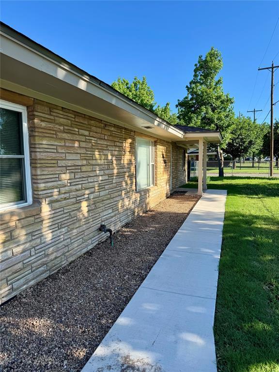 6101 S Douglas Ave, Oklahoma City, OK 73139 - view of home's exterior with a lawn and stone siding
