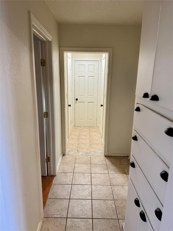 6101 S Douglas Ave, Oklahoma City, OK 73139 - hallway with light tile patterned flooring and a textured ceiling