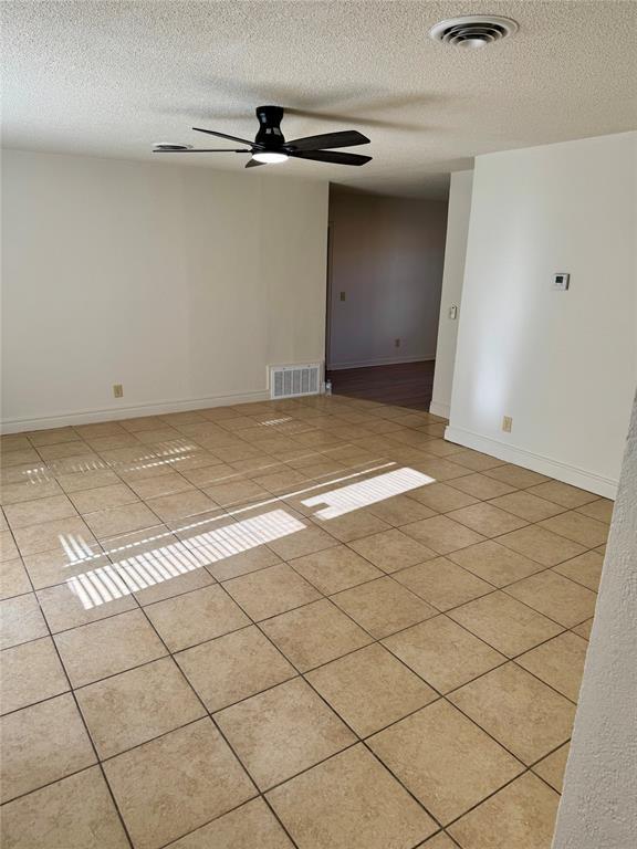 6101 S Douglas Ave, Oklahoma City, OK 73139 - empty room featuring a textured ceiling, a ceiling fan, and light tile patterned floors