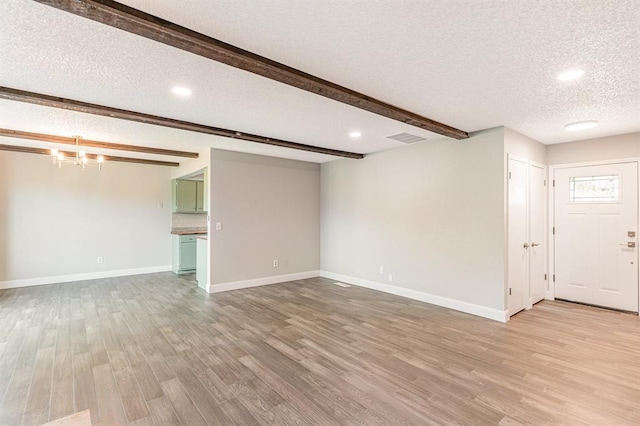 1004 Ranchoak Ct, Yukon, OK 73099 - unfurnished living room featuring a textured ceiling, light wood finished floors, a chandelier, beamed ceiling, and recessed lighting