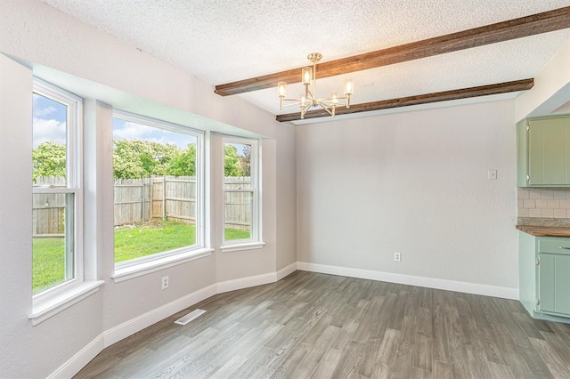 1004 Ranchoak Ct, Yukon, OK 73099 - unfurnished dining area with beamed ceiling, a chandelier, light wood-type flooring, and a textured ceiling