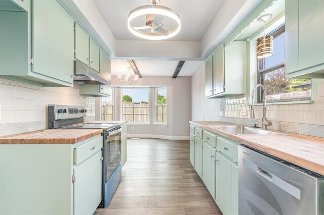 1004 Ranchoak Ct, Yukon, OK 73099 - kitchen with appliances with stainless steel finishes, wood counters, under cabinet range hood, light wood-style flooring, and tasteful backsplash
