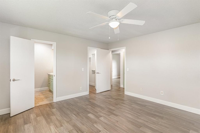 1004 Ranchoak Ct, Yukon, OK 73099 - unfurnished bedroom with light wood-style floors, a walk in closet, ensuite bath, a ceiling fan, and a closet