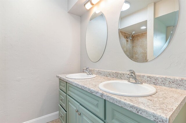 1004 Ranchoak Ct, Yukon, OK 73099 - bathroom featuring double vanity, a shower, and a textured wall
