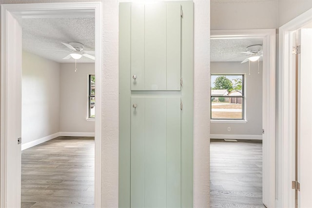 1004 Ranchoak Ct, Yukon, OK 73099 - hall featuring a textured ceiling and wood finished floors
