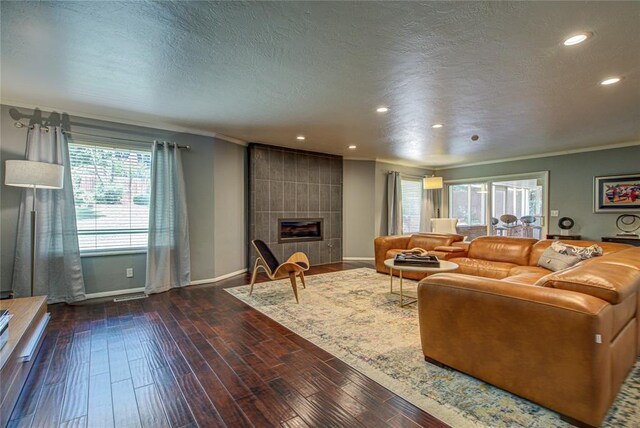 4973 NW 31st Ter, Oklahoma City, OK 73122 - living room with recessed lighting, a textured ceiling, ornamental molding, dark wood-style flooring, and a tile fireplace