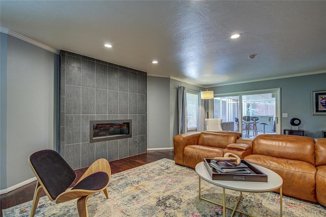 4973 NW 31st Ter, Oklahoma City, OK 73122 - living room with ornamental molding, wood finished floors, a tile fireplace, and recessed lighting