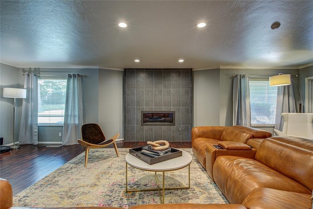 4973 NW 31st Ter, Oklahoma City, OK 73122 - living area featuring wood finished floors, crown molding, recessed lighting, a textured ceiling, and a fireplace