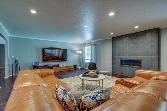4973 NW 31st Ter, Oklahoma City, OK 73122 - living room featuring crown molding, a tile fireplace, wood finished floors, recessed lighting, and a textured ceiling