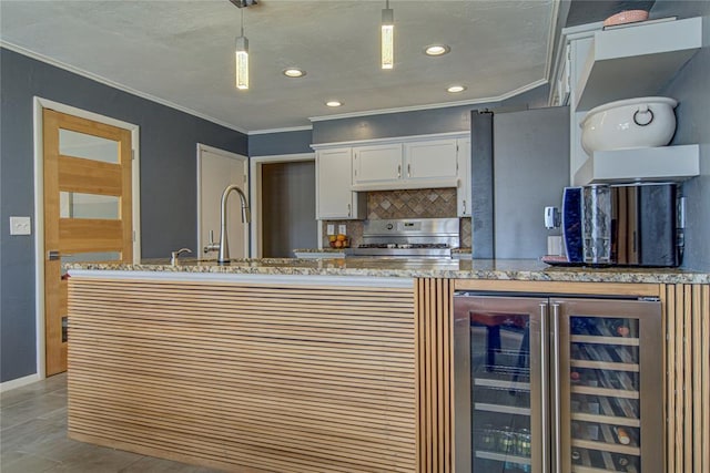 4973 NW 31st Ter, Oklahoma City, OK 73122 - kitchen featuring stainless steel range, wine cooler, crown molding, white cabinets, and tasteful backsplash