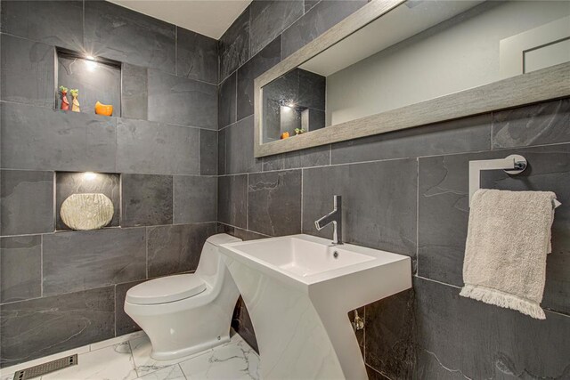 4973 NW 31st Ter, Oklahoma City, OK 73122 - half bathroom featuring tile walls and marble finish flooring