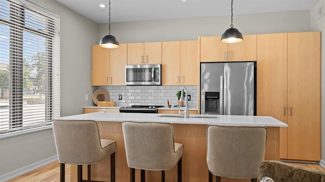 627 Couch Dr Unit S05, Oklahoma City, OK 73102 - kitchen with stainless steel appliances, light countertops, tasteful backsplash, a kitchen bar, and pendant lighting