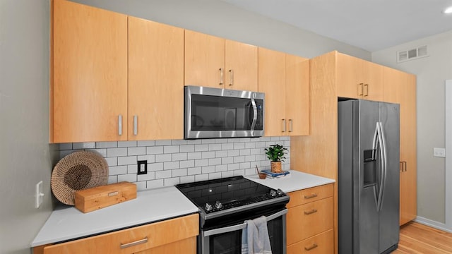 627 Couch Dr Unit S05, Oklahoma City, OK 73102 - kitchen with stainless steel appliances, decorative backsplash, light countertops, and light wood-style floors