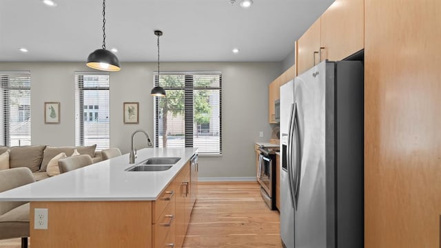 627 Couch Dr Unit S05, Oklahoma City, OK 73102 - kitchen with appliances with stainless steel finishes, light wood-style flooring, light countertops, a center island with sink, and a breakfast bar