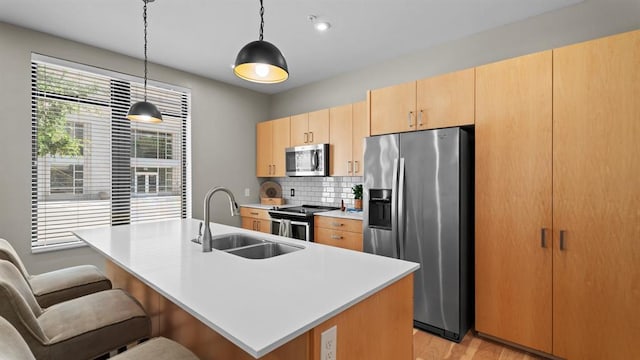 627 Couch Dr Unit S05, Oklahoma City, OK 73102 - kitchen with stainless steel appliances, light countertops, tasteful backsplash, a kitchen bar, and a center island with sink