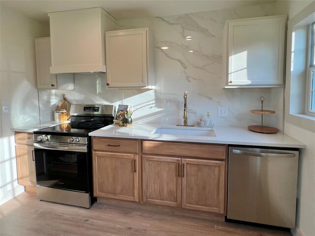 2332 NW 31st St, Oklahoma City, OK 73112 - kitchen featuring appliances with stainless steel finishes, backsplash, light wood-style floors, and light countertops