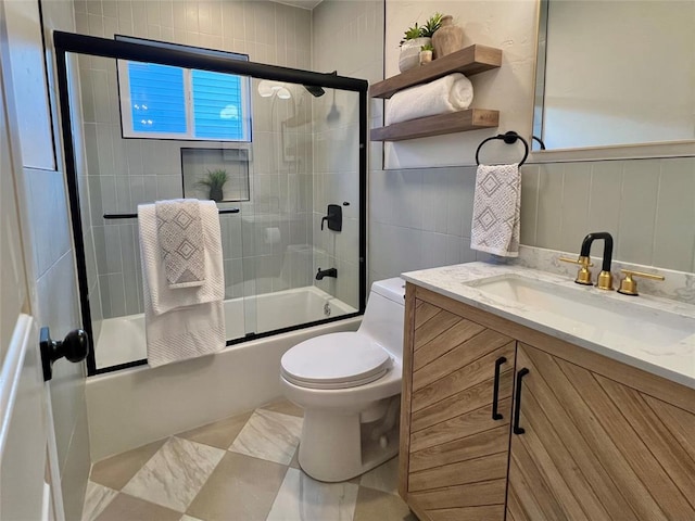 2332 NW 31st St, Oklahoma City, OK 73112 - full bathroom featuring bath / shower combo with glass door, vanity, and a wainscoted wall