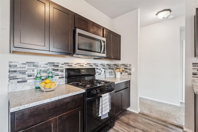 1016 N Deer Court Way, Mustang, OK 73064 - kitchen with gas stove, stainless steel microwave, dark brown cabinets, wood finished floors, and backsplash