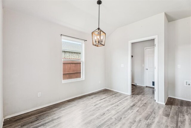 1016 N Deer Court Way, Mustang, OK 73064 - unfurnished room with wood finished floors, a chandelier, and lofted ceiling